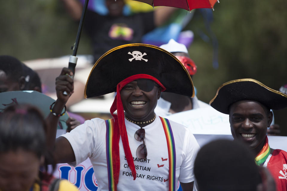 A Ugandan man wearing a pirate's hat marches during the 3rd Annual Lesbian, Gay, Bisexual and Transgender (LGBT) Pride celebrations in Entebbe, Uganda, Saturday, Aug. 9, 2014.  Scores of Ugandan homosexuals and their supporters are holding a gay pride parade on a beach in the lakeside town of Entebbe. The parade is their first public event since a Ugandan court invalidated an anti-gay law that was widely condemned by some Western governments and rights watchdogs. .(AP Photo/Rebecca Vassie)