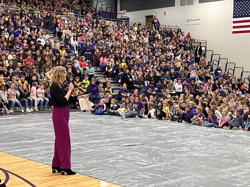 Jessica Hiser, director of marketing and advertising for Spherion Mid Ohio, talks to the crowd at a Friday pep rally in Lexington's high school gym.