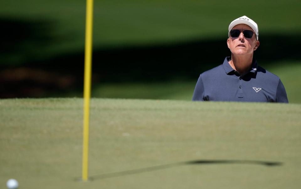 Phil Mickelson watches his bunker shot on the seventh hole