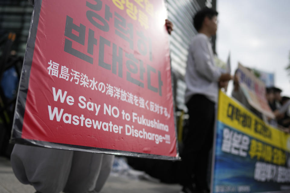 A Buddhist monk, hold signs during a rally to oppose Japanese government's plan to release treated radioactive water into the sea from the Fukushima nuclear power plant, in Seoul, South Korea, Wednesday, July 5, 2023. (AP Photo/Lee Jin-man)