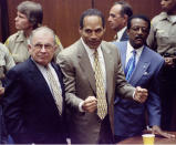 Defendant O.J. Simpson reacts after the court clerk announces that Simpson was found not guilty of the murders of Nicole Simpson and Ronald Goldman, as defense attorneys F. Lee Bailey (L) and Johnnie Cochran, Jr. (R) look on in a Los Angeles courtroom, October 3, 1995. REUTERS/Myung J. Chun/Pool