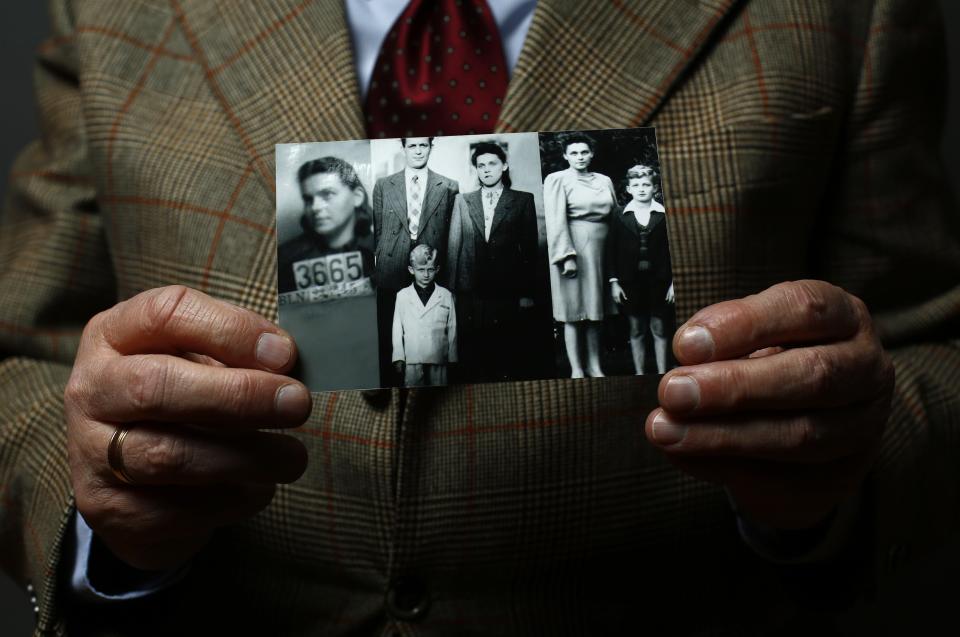 Auschwitz death camp survivor Jacek Nadolny holds up a wartime photo of his family in Warsaw