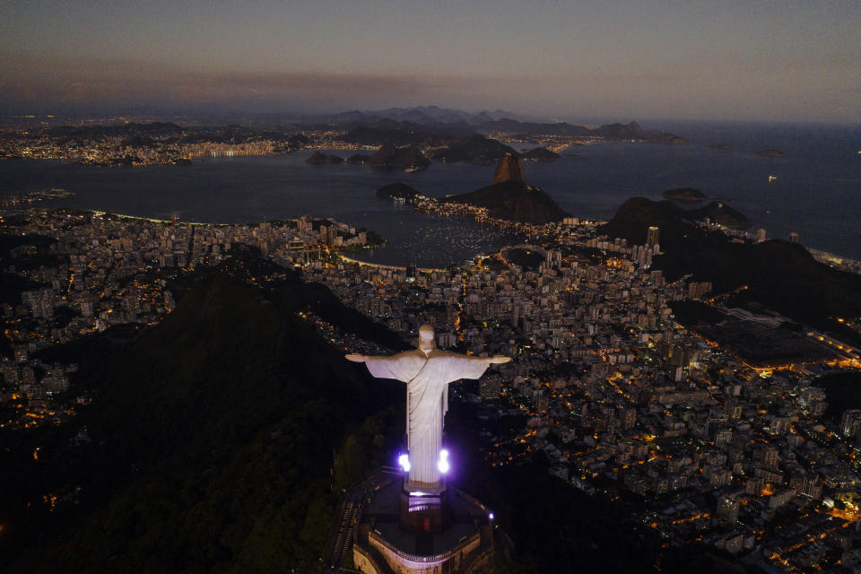 The Christ the Redeemer statue stands above the Guanabara bay during dusk amid the outbreak of the coronavirus in Rio de Janeiro, Brazil, Monday, April 27, 2020. (AP Photo/Leo Correa)