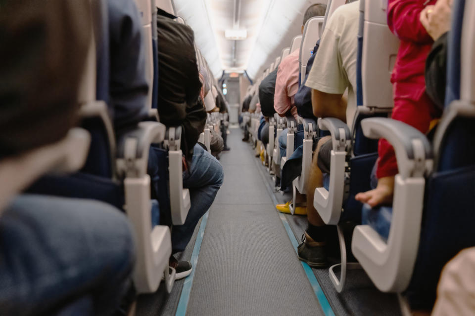 look down the plane aisle of a full flight