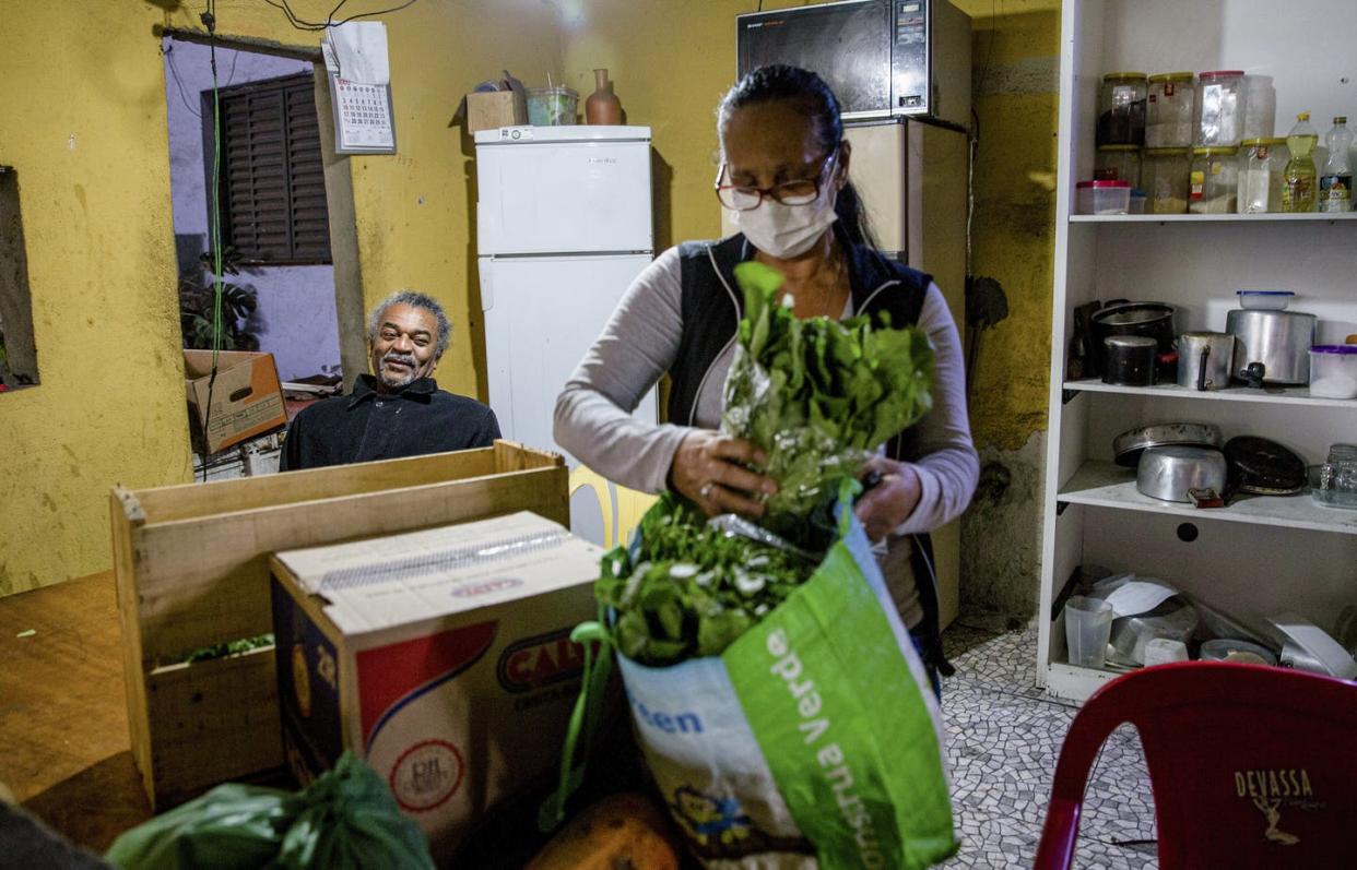 <span class="caption">Ladijane Sofia da Concecão, one of millions of unemployed housekeepers in Brazil, accepts a food donation from a friend in São Paulo, May 7, 2020. </span> <span class="attribution"><a class="link " href="https://www.gettyimages.com/detail/news-photo/nilson-garrido-shares-part-of-the-donations-he-received-news-photo/1212731072?adppopup=true" rel="nofollow noopener" target="_blank" data-ylk="slk:Alexandre Schneider/Getty Images;elm:context_link;itc:0;sec:content-canvas">Alexandre Schneider/Getty Images</a></span>