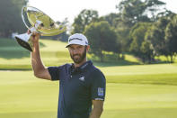 Dustin Johnson celebrates with the FedEx Cup trophy after winning the Tour Championship golf tournament on Monday, Sept. 7, 2020 at Lake Golf Club in Atlanta. (AP Photo/John Bazemore)