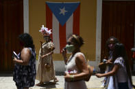 A group of activists march demanding statues and street names commemorating symbols of colonial oppression be removed, in San Juan, Puerto Rico, Saturday, July 11, 2020. Dozens of activists marched through the historic part of Puerto Rico’s capital on Saturday to demand that the U.S. territory’s government start by removing statues, including those of explorer Christopher Columbus. (AP Photo/Carlos Giusti)