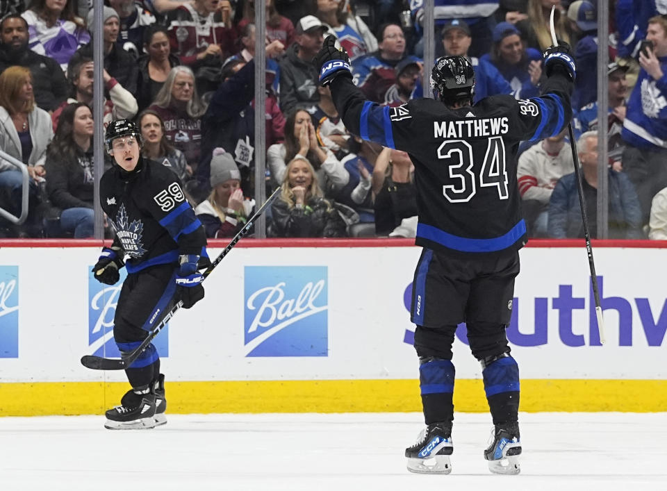 Toronto Maple Leafs left wing Tyler Bertuzzi, back, reeacts after scoring his third goal of the contest as center Auston Matthews celebrates in the third period of an NHL hockey game against the Colorado Avalanche Saturday, Feb. 24, 2024, in Denver. (AP Photo/David Zalubowski)
