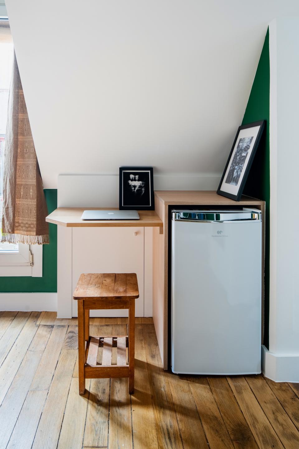 The little cabinet underneath the desk space is a perfect place for stowing liquor bottles. With a square footage so small, it's important to tuck things away wherever you can.