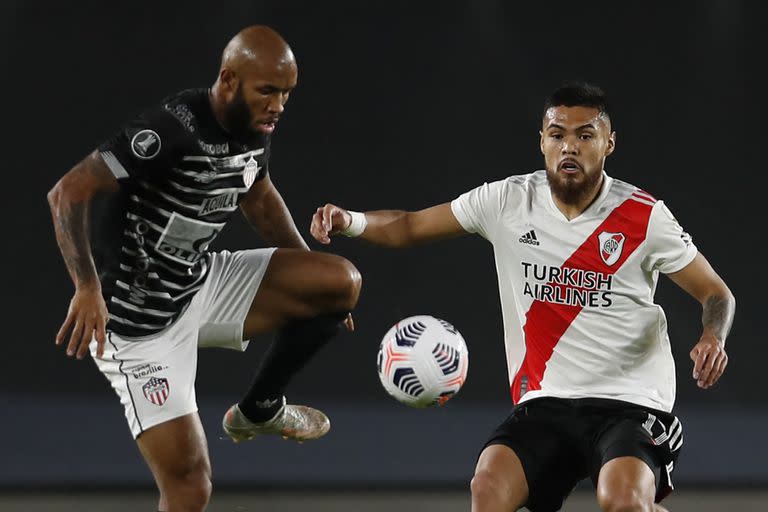 Colombia's Junior Fredy Hinestroza (L) and Argentina's River Plate Chilean Paulo Diaz vie for the ball during their Copa Libertadores football tournament group stage match at the Monumental Stadium in Buenos Aires on April 28, 2021. (Photo by Natacha Pisarenko / POOL / AFP)