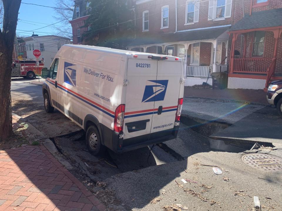 A U.S. Postal Service truck got stuck when part of a Wilmington street collapsed after a water main broke Wednesday morning (Feb. 14, 2024).