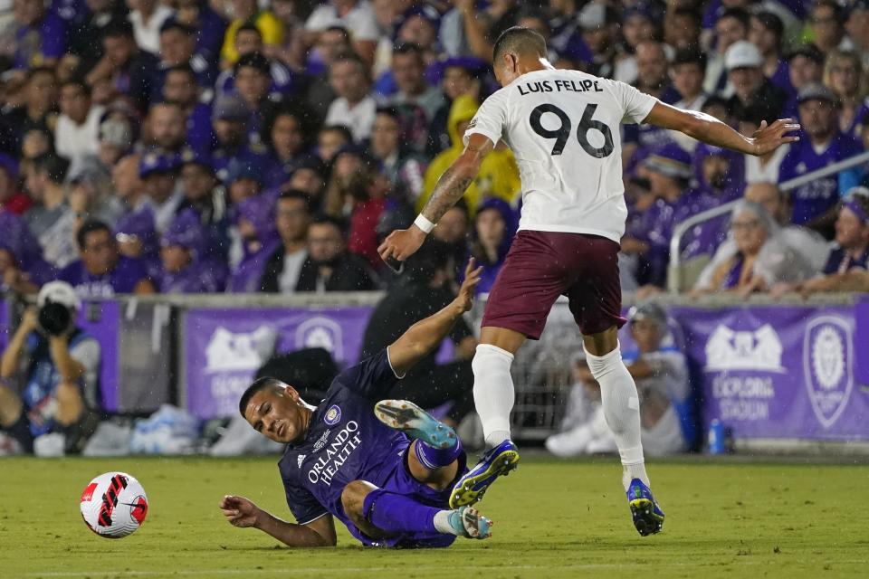 Orlando City's Cesar Araujo, left, goes down as he tries to get possession of the ball away from Sacramento Republic's Luis Felipe (96) during the first half of the U.S. Open Cup final soccer match Wednesday, Sept. 7, 2022, in Orlando, Fla. (AP Photo/John Raoux)