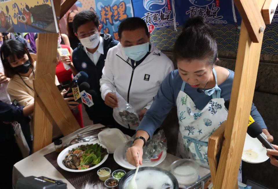 貢寮在地料理女王蔡季芳在記者會現場示範貢寮鮑料理，市長侯友宜在旁直呼「讚」。　（記者吳瀛洲攝）