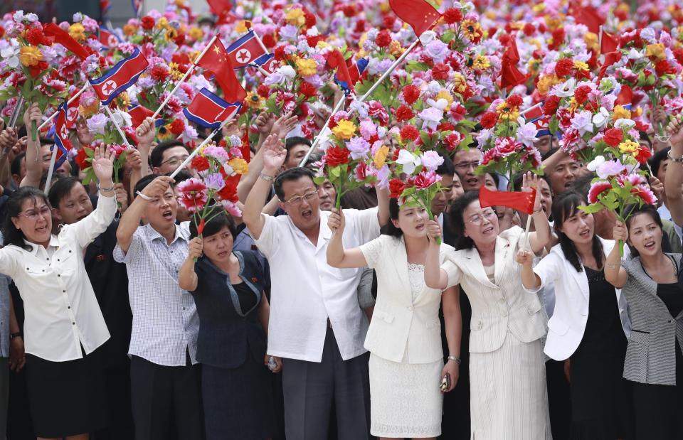 In this photo provided by China's Xinhua News Agency, people welcome Chinese President Xi Jinping at the Sunan International Airport in Pyongyang, Thursday, June 20, 2019. President Xi arrived in Pyongyang Thursday for a state visit to North Korea. (Pang Xinglei/Xinhua News Agency via AP)