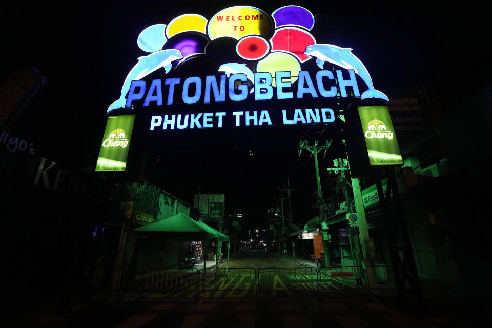 The glowing entrance gate to the normally tourist-filled Bangla walking street, sits empty in Patong Beach on Phuket, southern Thailand, Monday, June 28, 2021. Thailand's government will begin the "Phuket Sandbox" scheme to bring the tourists back to Phuket starting July 1. Even though coronavirus numbers are again rising around the rest of Thailand and prompting new lockdown measures, officials say there's too much at stake not to forge ahead with the plan to reopen the island to fully-vaccinated travelers. (AP Photo/Sakchai Lalit)