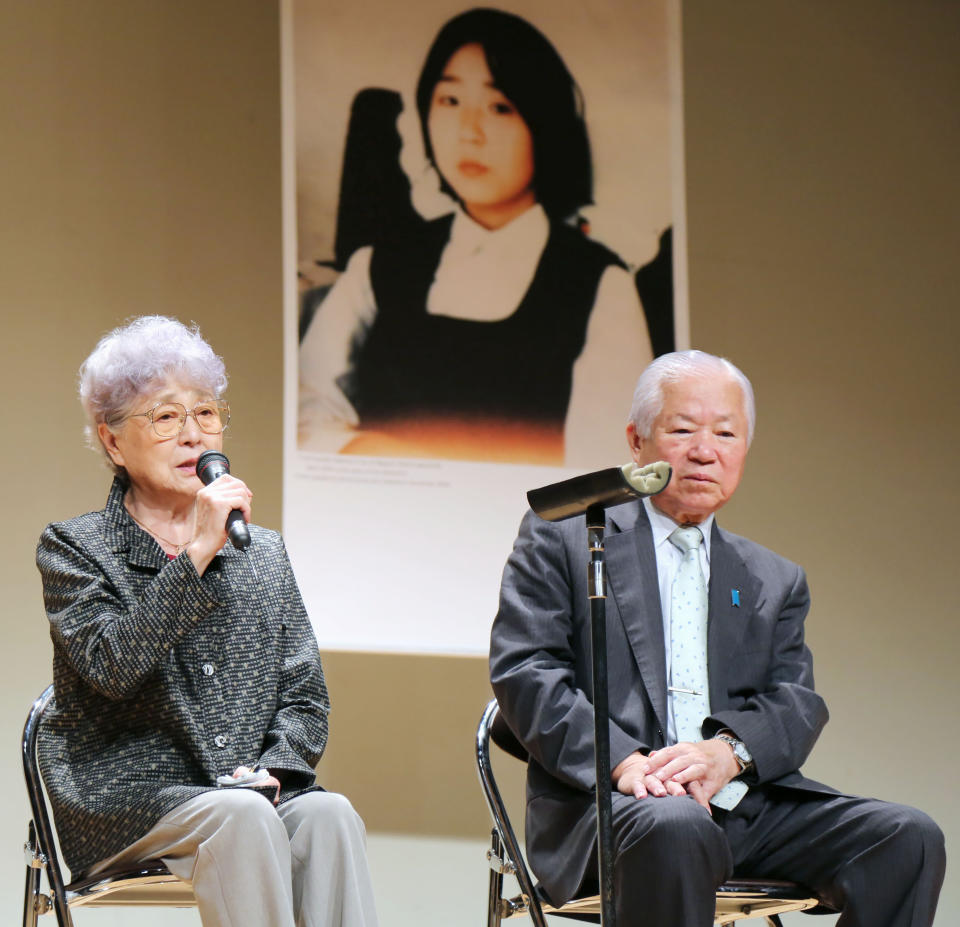 Shigeru Yokota listens to his wife Sakie, the parents of Megumi Yokota who was abducted by North Korea in 1977, during a meeting in front of Megumi's photo, in Niigata, Japan in September, 2014. Shigeru Yokota died of natural causes before he was able to meet his daughter again, his group said Friday, June 5, 2020. He was 87. (Kyodo News via AP)