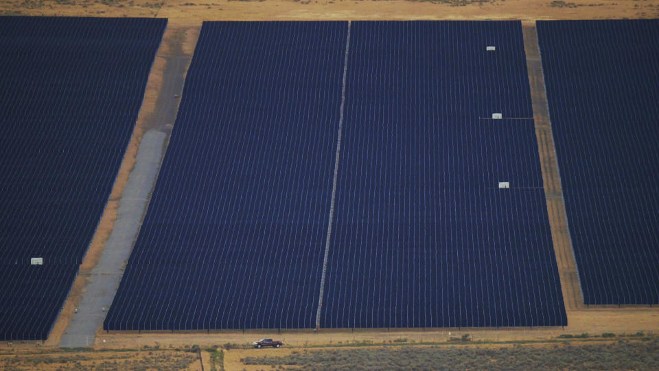 FILE - A vehicle moves near a solar farm Aug. 9, 2022, in Mona, Utah. Electricity generated from renewables surpassed coal in the United States for the first time in 2022, the U.S. Energy Information Administration announced Monday, March 27, 2023. (AP Photo/Rick Bowmer, File)