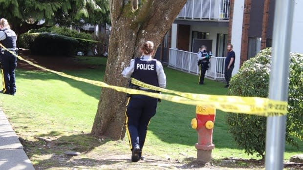 Police in Coquitlam near Gatensbury Street and Howie Avenue tape off a scene where a man was shot around 11:00 a.m. on Sunday April 4, 2021. (Shane MacKichan - image credit)