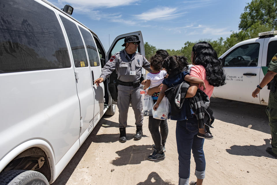 A Border Patrol agent prepares to load a van with illegal immigrants