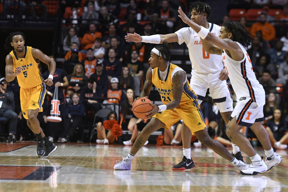 UMKC's RayQuawndis Mitchell (21) looks to pass the ball as Illinois' Skyy Clark (55) and Terrence Shannon Jr. (0) defend during the second half of an NCAA college basketball game Friday, Nov. 11, 2022, in Champaign, Ill. (AP Photo/Michael Allio)