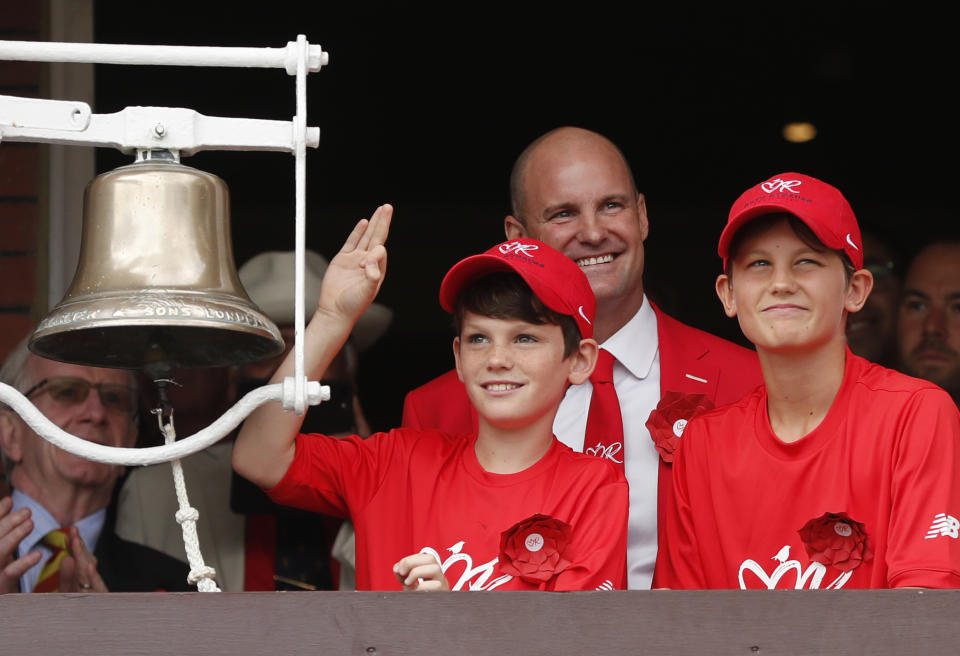 Former England cricketer Andrew Strauss, centre, with his sons Sam, right, and Luca, left, as they prepare to ring the bell, as Lord's cricket ground is turned red in aid of the Ruth Strauss Foundation, ahead of the second day of the second Ashes test match between England and Australia at Lord's cricket ground in London, Thursday, Aug. 15, 2019. The Ruth Strauss Foundation was set up by former England cricketer Andrew Strauss in honour of his wife Ruth, who died from a rare form of lung cancer in December 2018. (AP Photo/Frank Augstein)