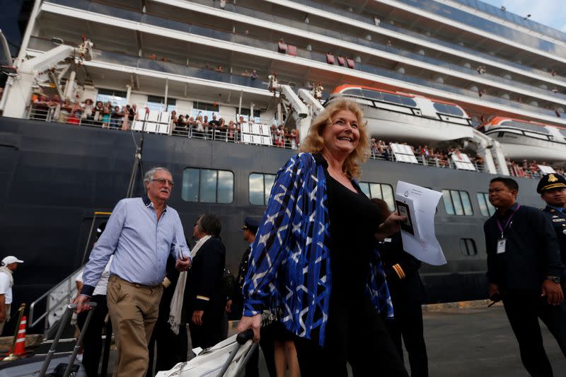 Passengers of MS Westerdam, a cruise ship that spent two weeks at sea after being turned away by five countries over fears that someone aboard might have the coronavirus, get off as it docks in Sihanoukville,