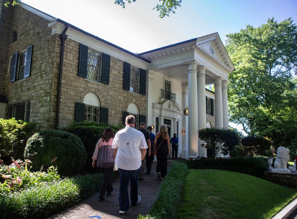 People walk along the path towards the mansion at Graceland for a tour in Memphis, Tenn., on Thursday, May 21, 2020. Graceland reopened in May for the first time since closing March 20 amid the coronavirus pandemic.