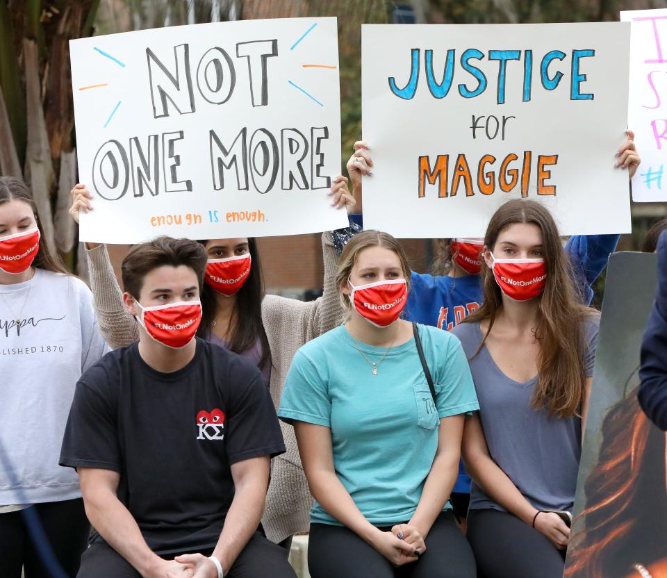 Friends of Sophia Lambert and Maggie Paxton, two UF students who died in pedestrian crashes along West University Ave. earlier this year, listen during a press conference as attorneys for the families of the two women killed read a statement from the families as they hold a press conference, in Gainesville Fla. March 3, 2021. Attorneys for the families have filed wrongful death lawsuits against the drivers and car owners in the crash.