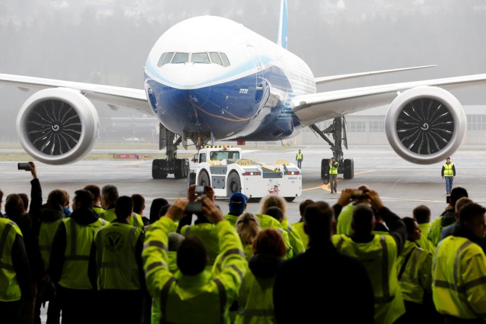 Boeing employees and others watch a Boeing 777X airplane return to a hangar after its first test flight: REUTERS