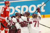 Latvia's Rihards Bukarts celebrates with teammates after scoring his side's third goal during the preliminary round match between Poland and Latvia at the Ice Hockey World Championships in Ostrava, Czech Republic, Saturday, May 11, 2024. (AP Photo/Darko Vojinovic)