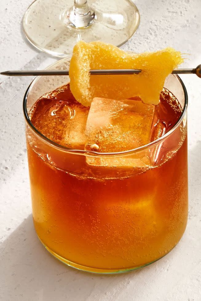 dark and stormy cocktail with an orange rind