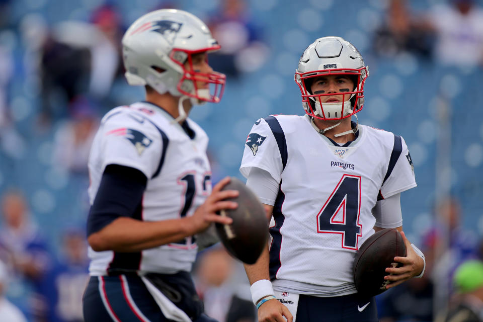 BUFFALO, NEW YORK - SEPTEMBER 29: Jarrett Stidham #4 of the New England Patriots looks on as Tom Brady #12 warms up prior to the game against the Buffalo Bills at New Era Field on September 29, 2019 in Buffalo, New York. (Photo by Brett Carlsen/Getty Images)