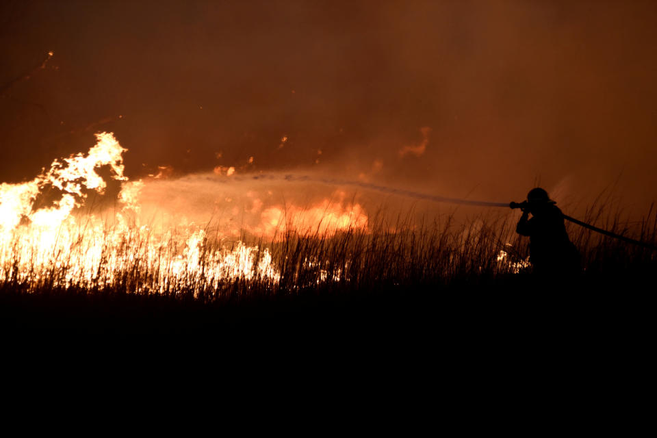 A firefighter works to control the Rhea&nbsp;wildfire near Seiling, Oklahoma,&nbsp;on April 17. (Photo: Nick Oxford / Reuters)