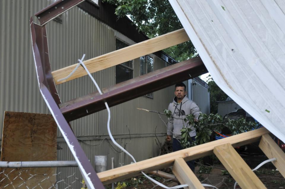 Santiago Rodriguez cleans up debris around his home after a tornado touched down in the Apollo Mobile Home Park in Oklahoma City, Oklahoma May 7, 2015. About a dozen people were injured by a series of tornadoes that touched down southwest of Oklahoma City, part of a storm system that flattened structures and caused severe flooding in several Great Plain states, officials said on Thursday.REUTERS/Nick Oxford