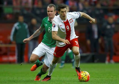 Poland's Robert Lewandowski is challenged by Republic of Ireland's Glenn Whelan (L) during their Euro 2016 group D qualification soccer match in Warsaw, Poland October 11, 2015. REUTERS/Kacper Pempel