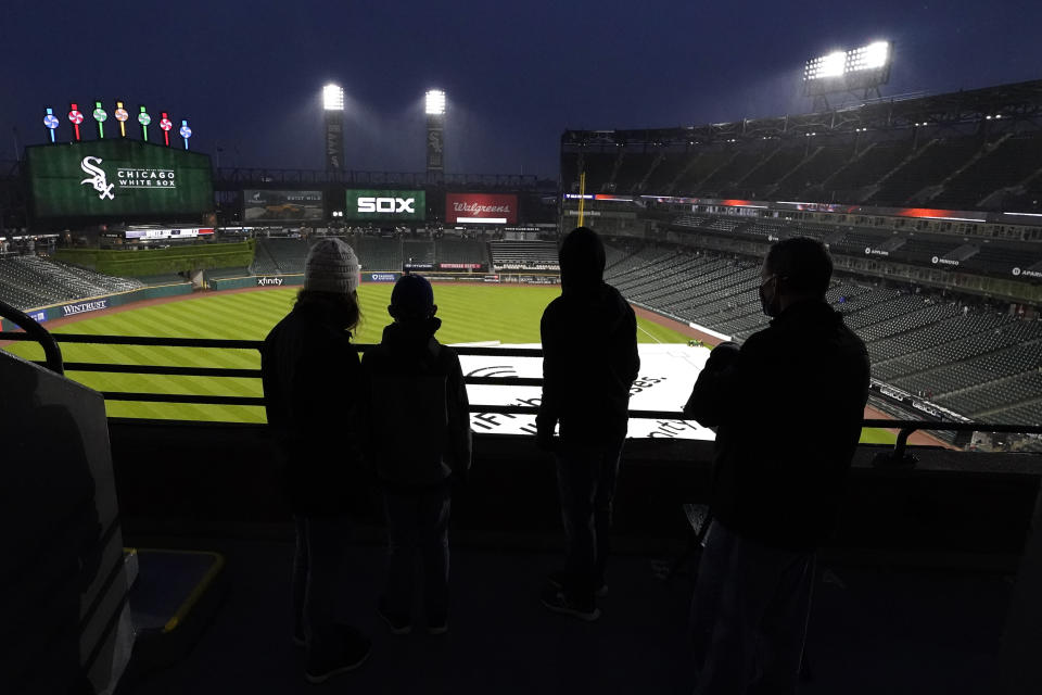 Fans look down the field as they leave the ballpark after a baseball game between the Chicago White Sox and the Baltimore Orioles was postponed due to rain, Friday, May 28, 2021. (AP Photo/Nam Y. Huh)