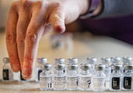 FILE - In this Jan. 14, 2021, file photo, Aspen Valley Hospital clinical pharmacist Kelly Atkinson organizes the empty vials of the Pfizer-BioNTech COVID-19 vaccine in the command unit trailer set up next to the vaccination tent in the Benedict Music Tent parking lot in Aspen, Colo. Uncertainty over the pace of federal COVID-19 vaccine allotments triggered anger and confusion Friday, Jan. 15, 2021, in some states where officials worried that expected shipments would not be forthcoming. (Kelsey Brunner/The Aspen Times via AP)