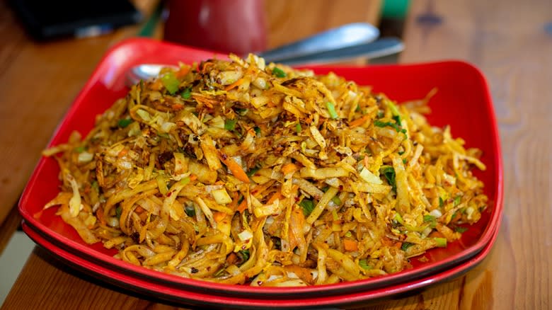 Shredded bread and vegetables on red plate 