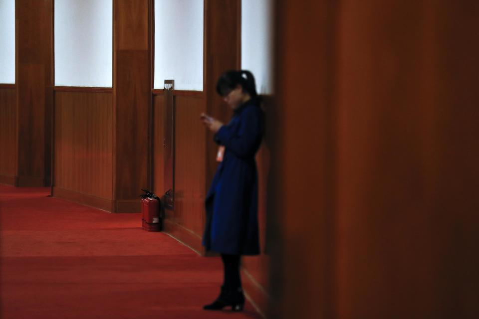 In this Friday, March 10, 2017 photo, a woman stands near the fire extinguishers placed outside the main meeting hall of the Chinese People's Political Consultative Conference (CPPCC) at the Great Hall of the People in Beijing. Because safety comes first, fire extinguishers are ubiquitous in and around Beijing’s Great Hall of the People during the annual sessions of China’s ceremonial parliament and its official advisory body. That’s partly for standard purposes of preventing any sort of fire-related emergency that could harm the participants and mar the proceedings. (AP Photo/Andy Wong)