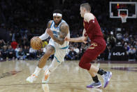 Charlotte Hornets forward Miles Bridges, left, drives against Cleveland Cavaliers guard Sam Merrill during the second half of an NBA basketball game, Monday, March 25, 2024, in Cleveland. (AP Photo/Ron Schwane)