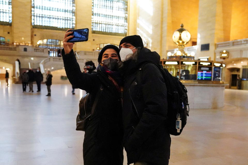 Two people wearing masks pose for a selfie photo in Grand Central Terminal.