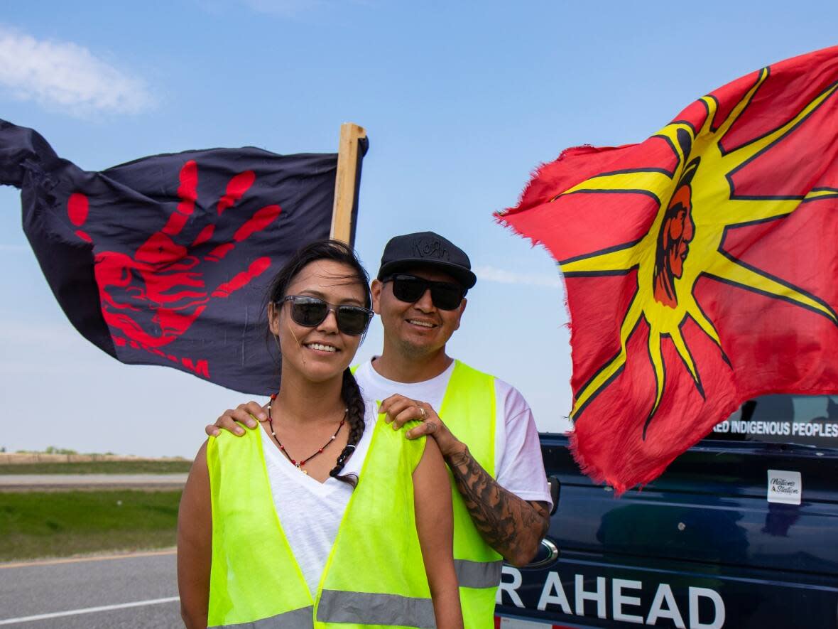 Charity and Cameron West walk on Highway 1 East near Brandon to raise awareness for missing and murdered Indigenous people in Canada on Saturday. (Chelsea Kemp/CBC - image credit)