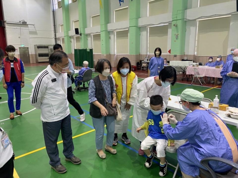 台北市副市長蔡炳坤和教育局副局長鄧進權一日到台北市中山區五常國小關心私幼、非營利幼兒園及市立幼兒園幼兒接種第二劑疫苗情形。（北市教育局提供）