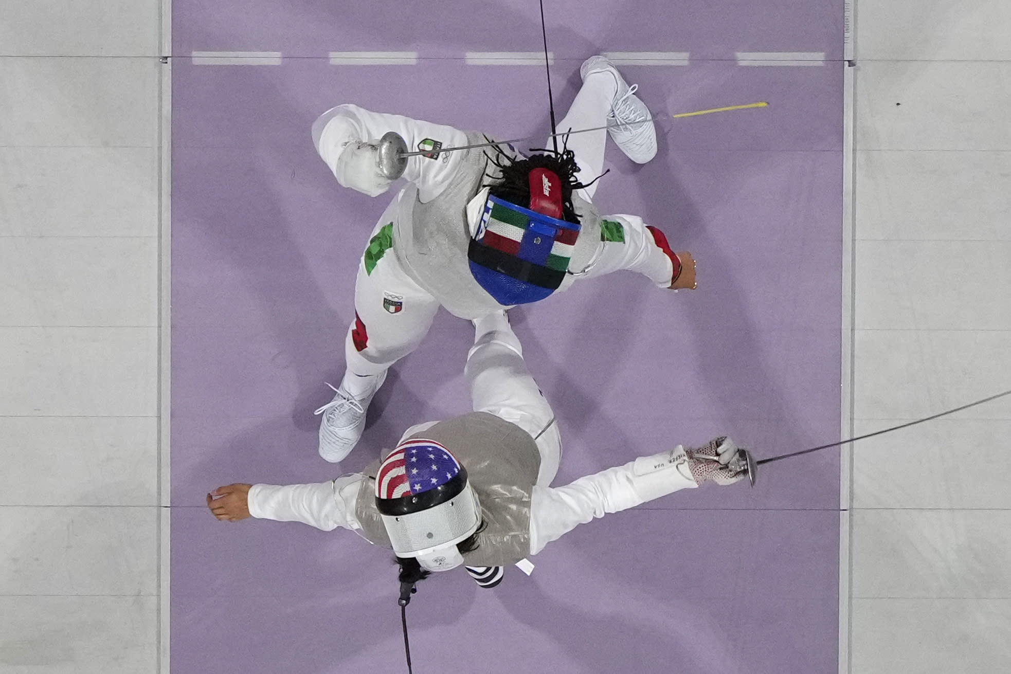 Seen from overhead, U.S. fencer Lee Kiefer competes with Italy's Alice Volpi, top, in the women's individual foil semifinal match. 