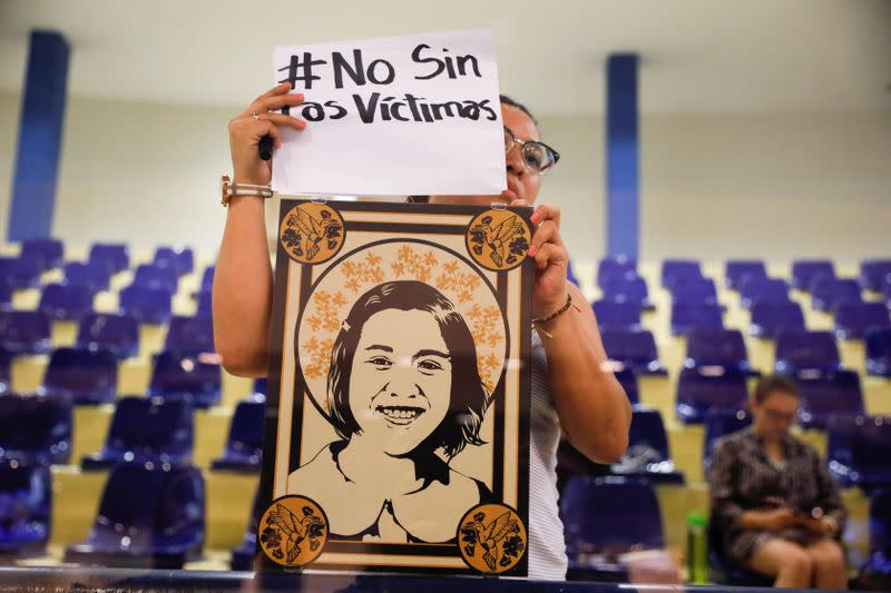 A woman holds a picture of her mother during a congress session to protest against approving an amnesty bill that exempts the prosecution of crimes committed during the civil war, in San Salvador, El Salvador