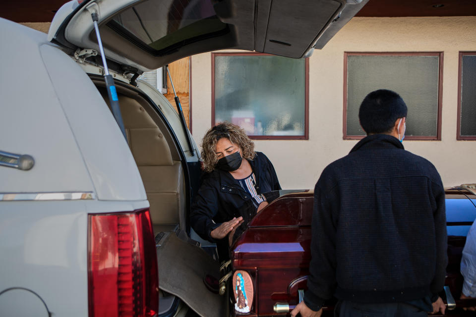 Magda Maldonado, propietaria de Continental Funeral Home en el este de Los Ángeles, limpia el polvo de un ataúd antes de que lo carguen en un camión y lo envíen a un servicio funerario, en el este de Los Ángeles, el 25 de febrero de 2021. (Alex Welsh para The New York Times)