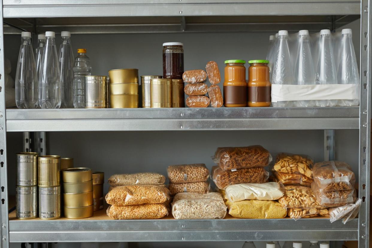 Background image of shelves stacked with food donations at help center for refugees and people in need, copy space