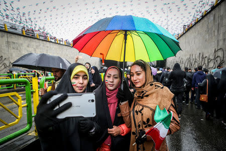 FILE PHOTO: An Iranian woman take selfies during a ceremony to mark the 40th anniversary of the Islamic Revolution in Tehran, Iran February 11, 2019. Vahid Ahmadi/Tasnim News Agency/via REUTERS