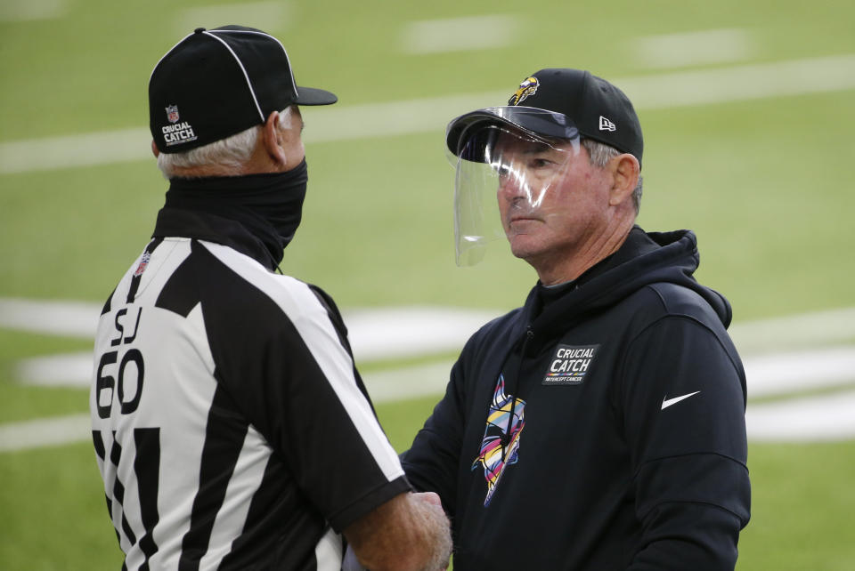 Minnesota Vikings head coach Mike Zimmer talks with side judge Gary Cavaletto, left, before an NFL football game against the Atlanta Falcons, Sunday, Oct. 18, 2020, in Minneapolis. (AP Photo/Bruce Kluckhohn)