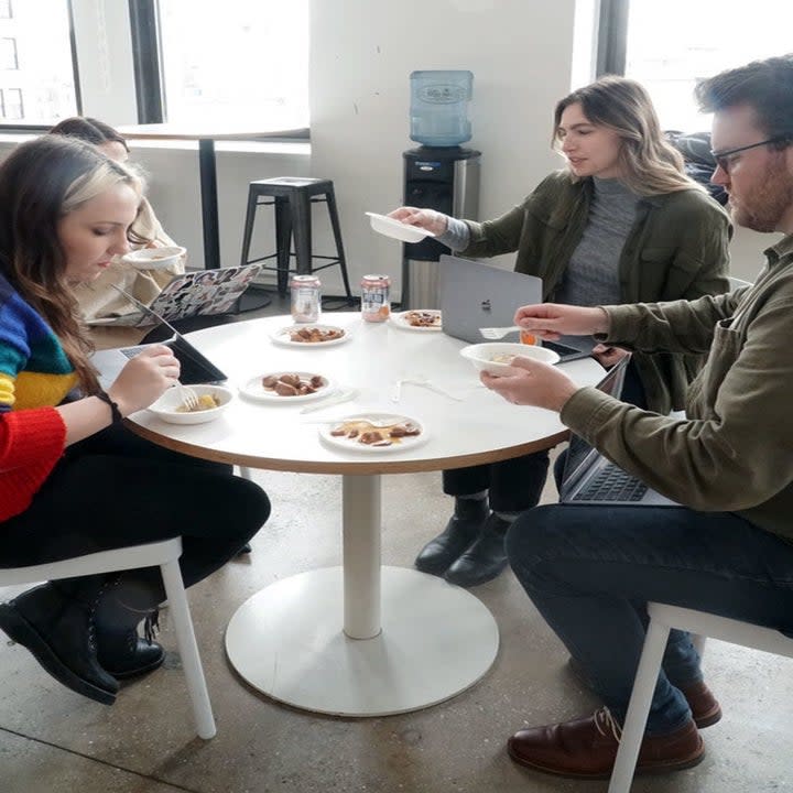 Four people sitting at a round table.